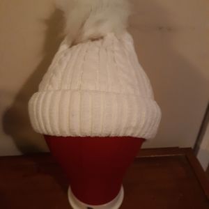 White lined winter hat with fluffy puff ball